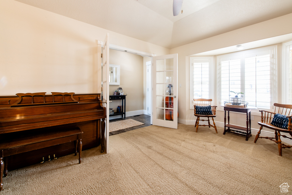 Living area featuring french doors, lofted ceiling, carpet flooring, ceiling fan, and baseboards