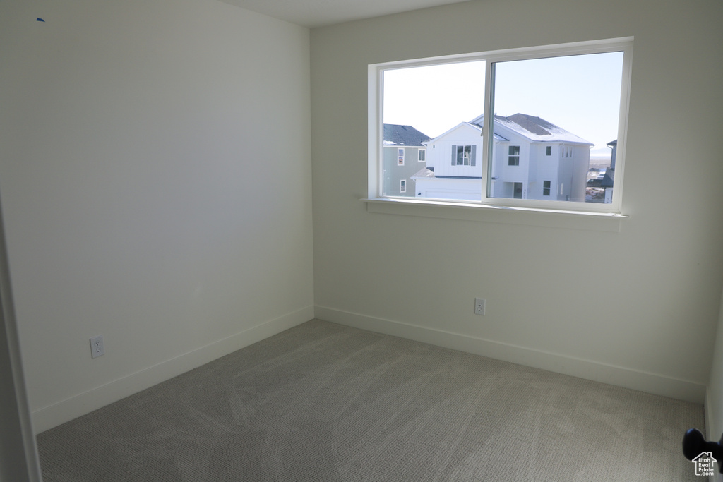 Carpeted spare room with baseboards