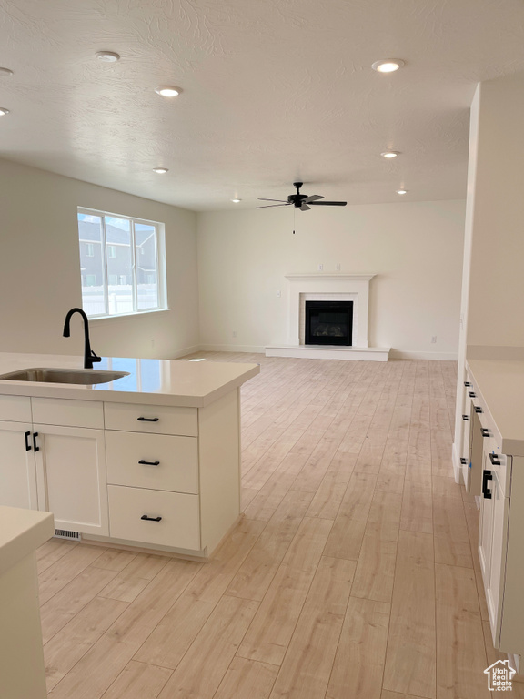 Kitchen featuring a ceiling fan, light wood-type flooring, light countertops, white cabinets, and recessed lighting