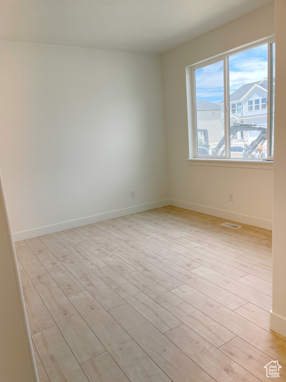 Spare room with light wood-style floors and baseboards