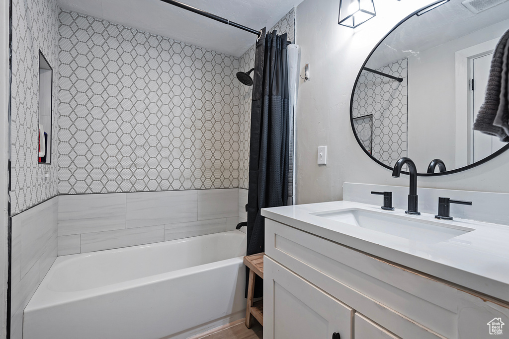 Bathroom with vanity and shower / tub combo with curtain