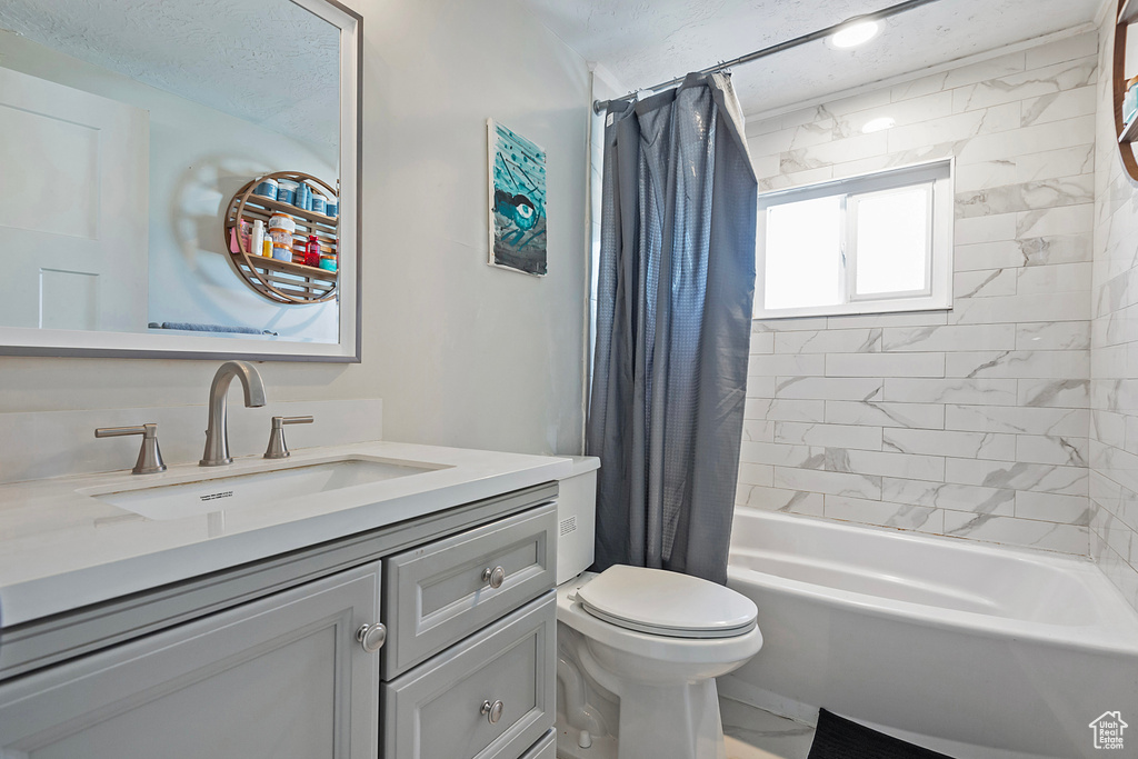 Full bathroom with shower / tub combo with curtain, vanity, and toilet