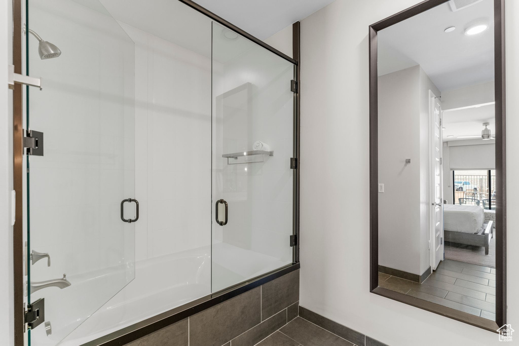 Ensuite bathroom with tile patterned floors, baseboards, connected bathroom, and a shower with shower door