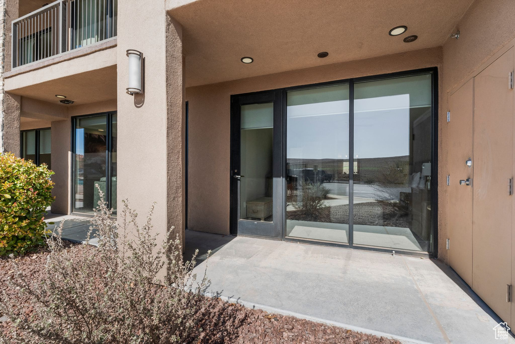 Property entrance featuring a balcony and stucco siding