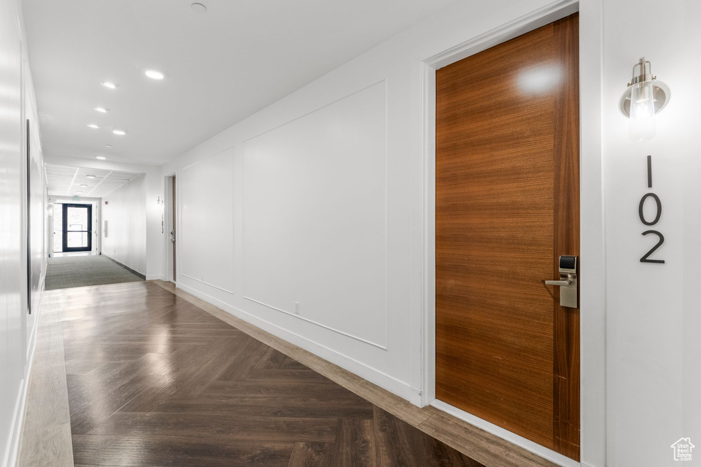 Corridor featuring recessed lighting and a decorative wall