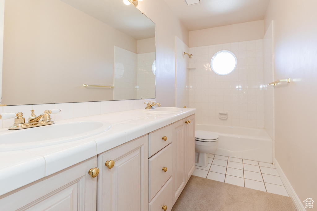 Full bath with double vanity, tile patterned flooring, a sink, and toilet