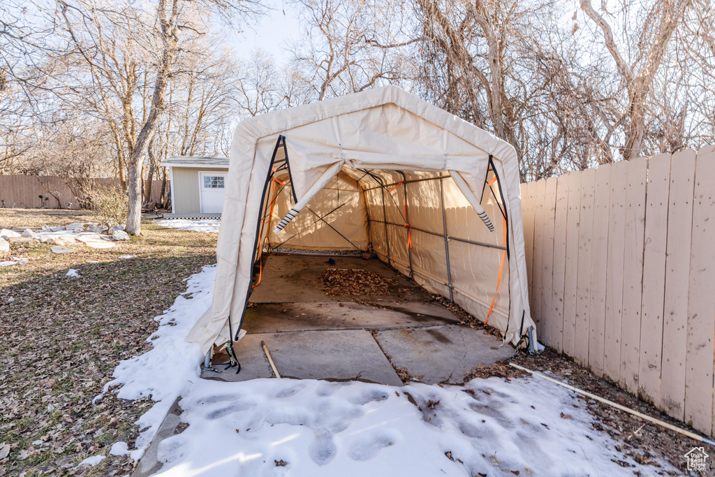 View of outbuilding with a garage, an outbuilding, and fence