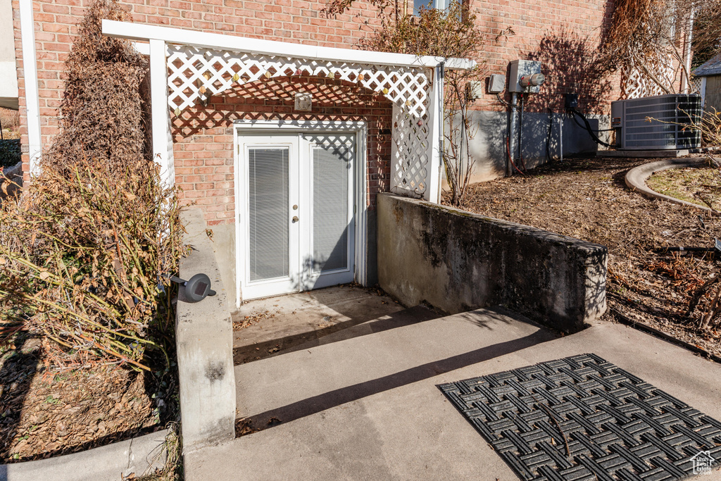 Property entrance featuring french doors and brick siding