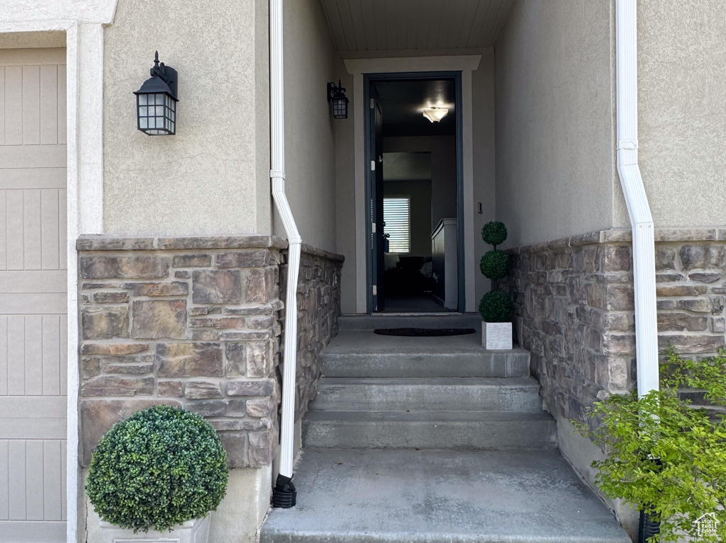 Entrance to property featuring stucco siding and stone siding