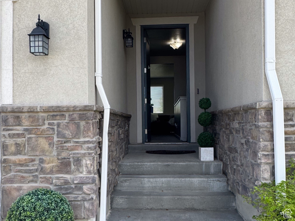 Entrance to property featuring stucco siding and stone siding