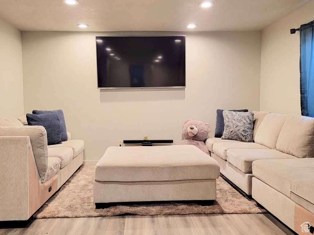 Living room featuring a textured ceiling, wood finished floors, visible vents, and recessed lighting
