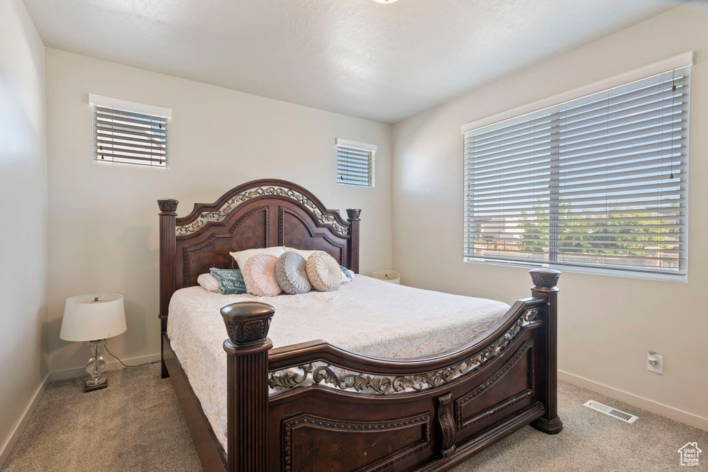 Bedroom featuring light colored carpet and baseboards
