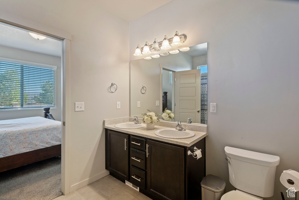 Ensuite bathroom featuring double vanity and tile patterned floors