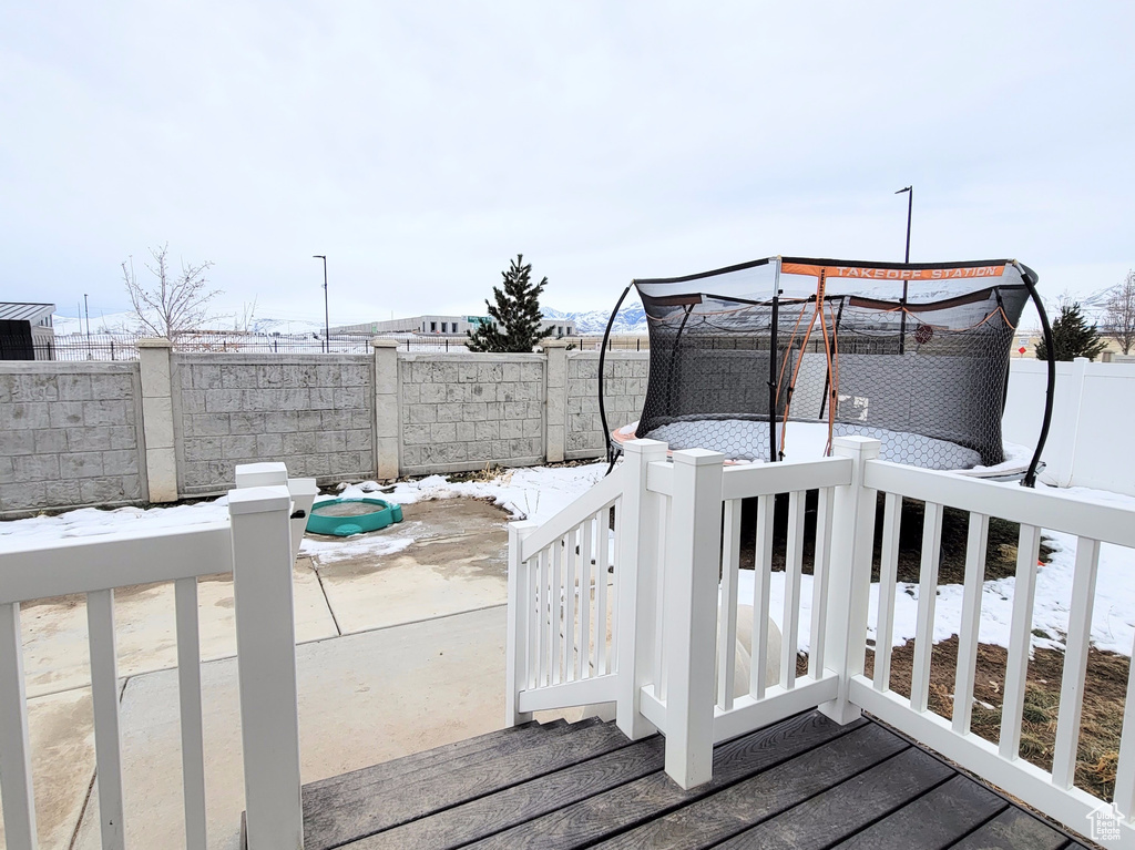 Wooden deck with a patio area and a fenced backyard