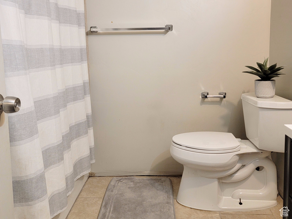 Full bath with tile patterned flooring, a shower with curtain, a textured ceiling, and toilet