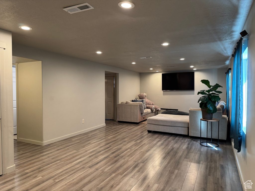 Living area with wood finished floors, visible vents, and recessed lighting