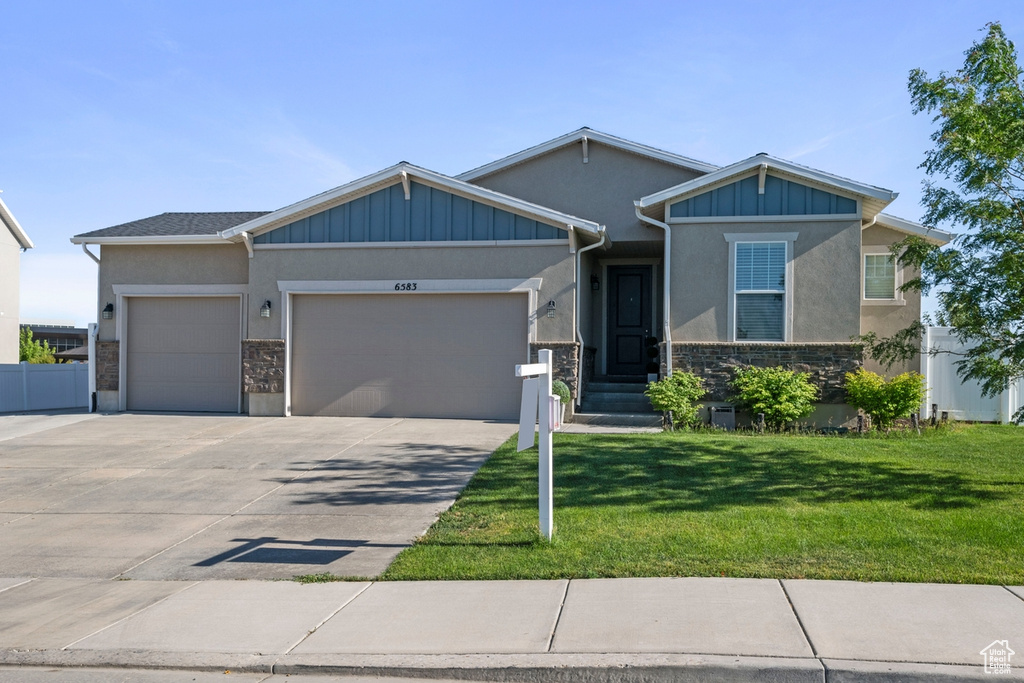 View of front of property with an attached garage, stucco siding, and driveway