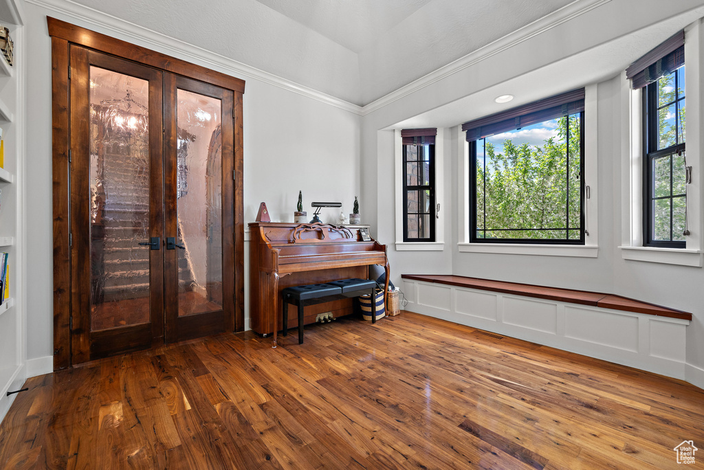 Entryway featuring wood-type flooring, ornamental molding, and french doors