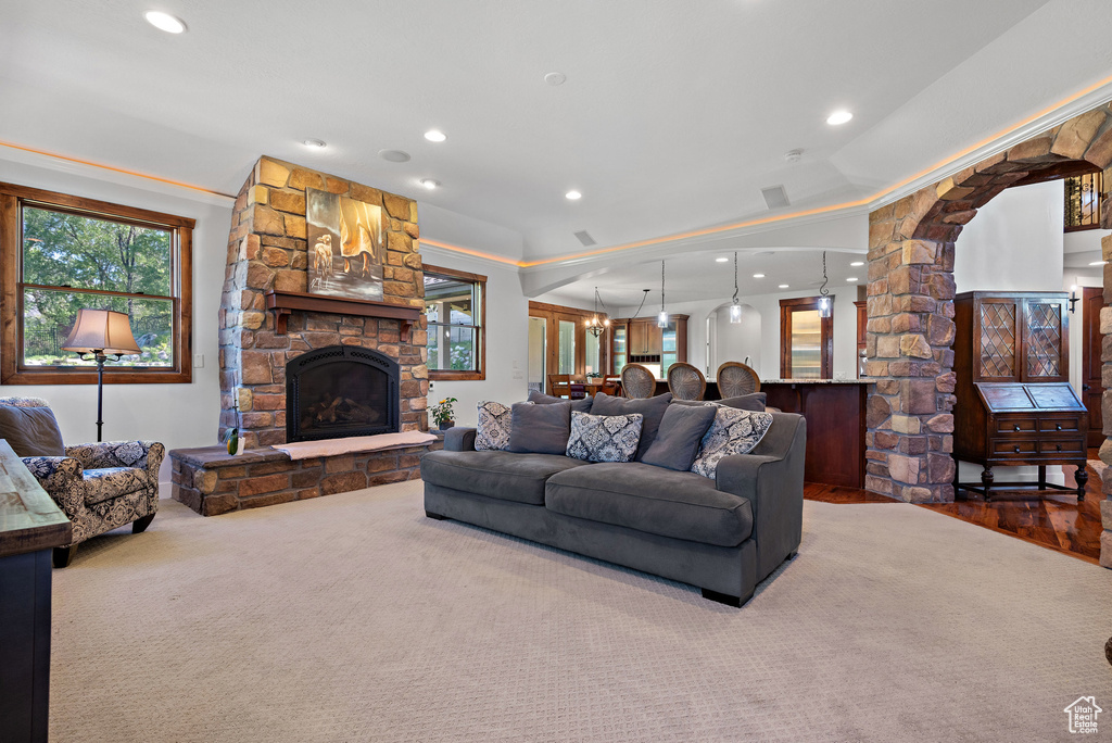 Living room with a stone fireplace, recessed lighting, ornate columns, and wood finished floors