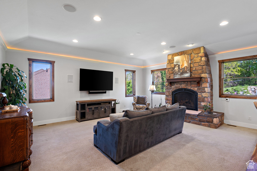 Carpeted living room with baseboards, plenty of natural light, and a fireplace