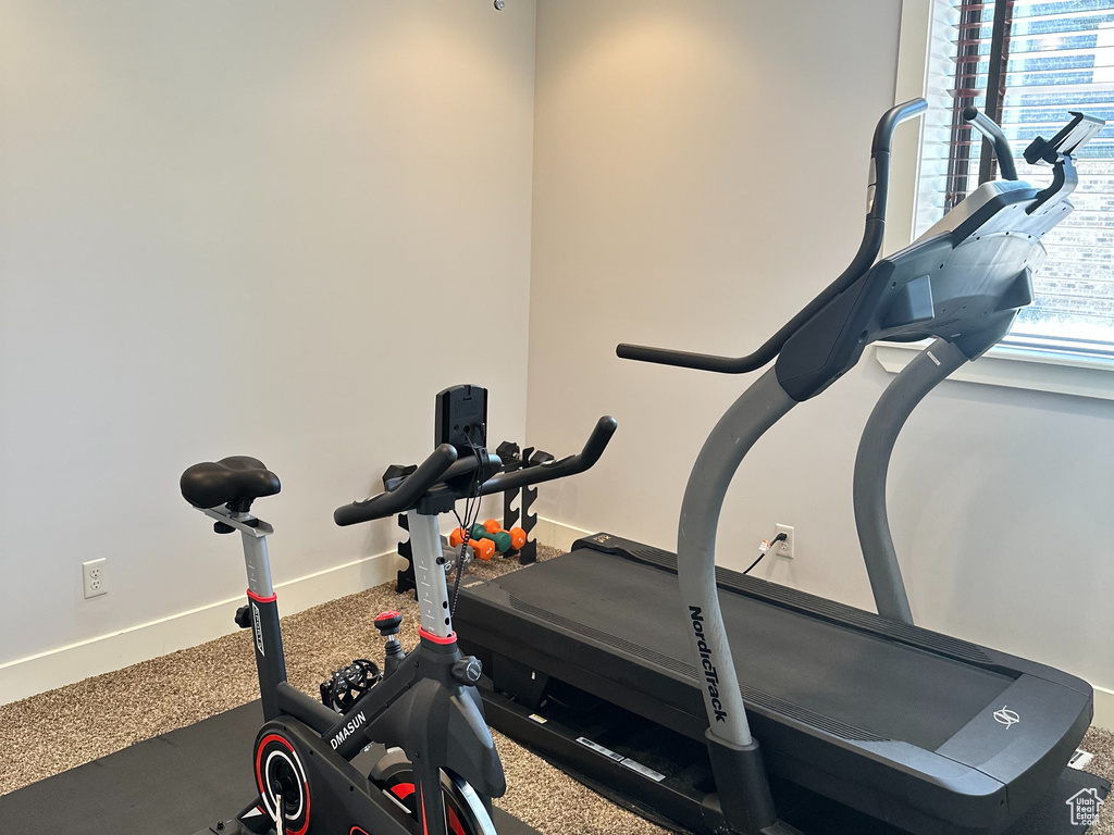 Exercise room featuring a ceiling fan, a textured ceiling, and baseboards