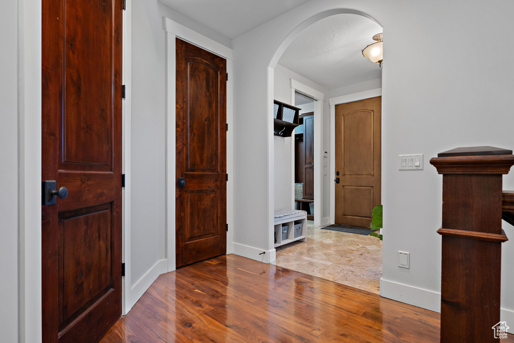 Entryway featuring arched walkways, baseboards, and wood finished floors