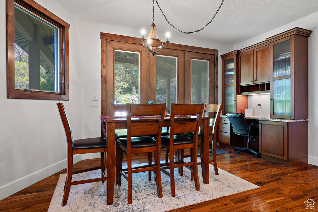 Dining area featuring baseboards, built in study area, and dark wood-type flooring