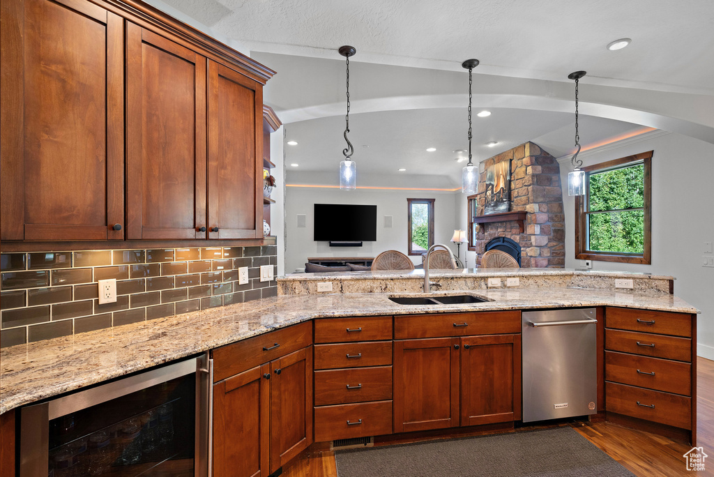 Kitchen featuring dishwasher, dark wood-style floors, a sink, and wine cooler