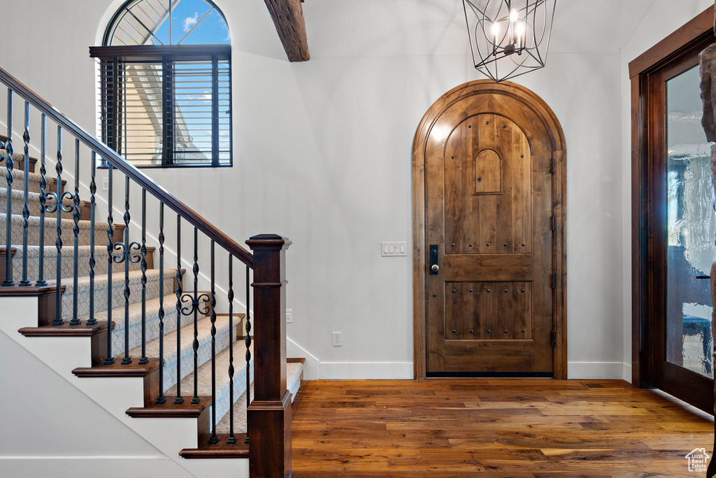 Entrance foyer with stairs, baseboards, and wood finished floors