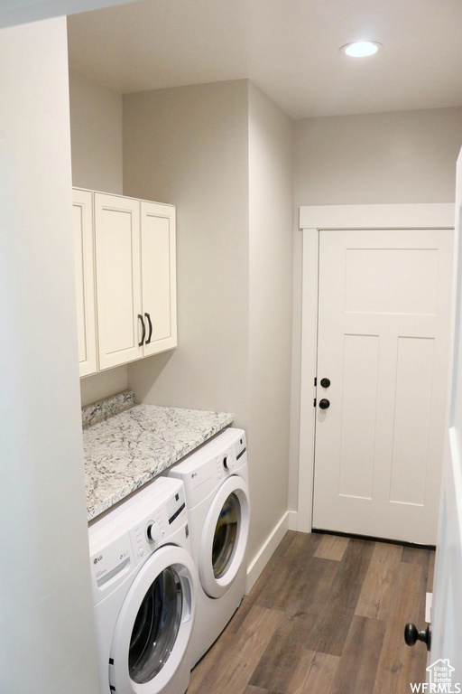 Laundry area featuring recessed lighting, dark wood-style flooring, baseboards, washer and dryer, and cabinet space