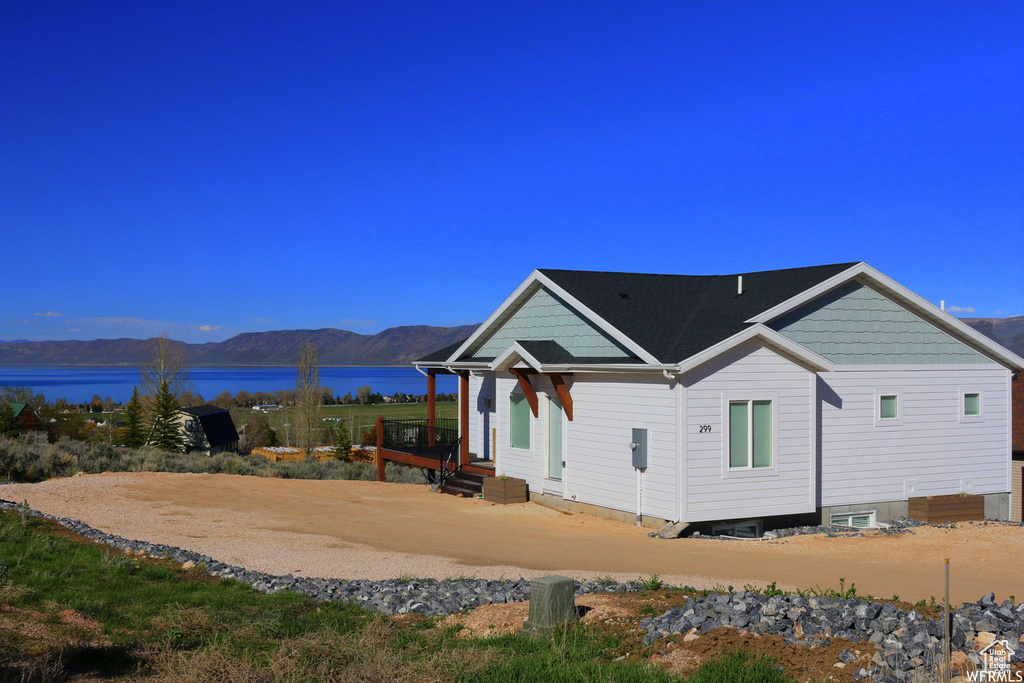 Rear view of property featuring entry steps and a water and mountain view