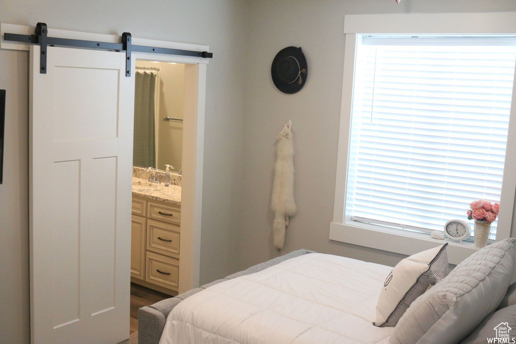 Bedroom with a sink, a barn door, and connected bathroom