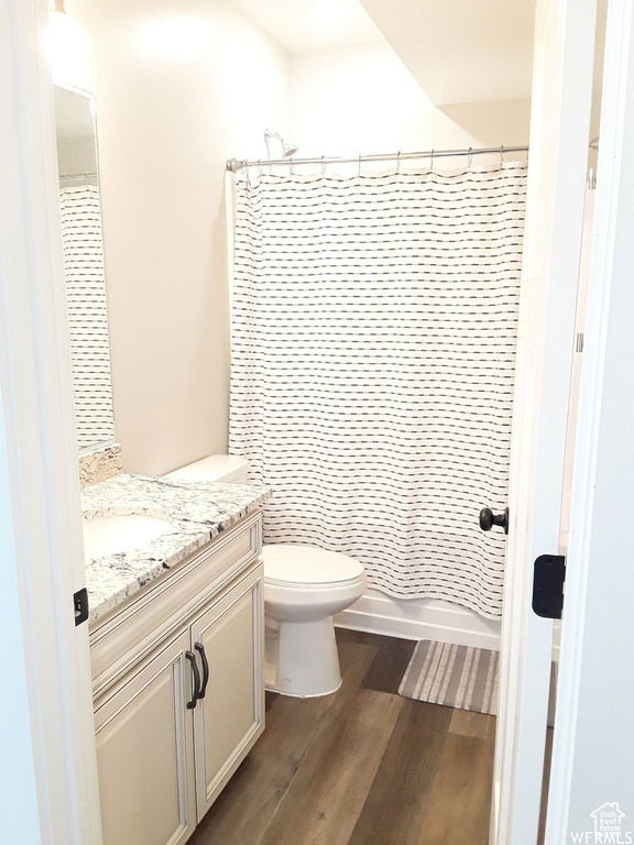 Full bathroom with toilet, wood finished floors, and vanity