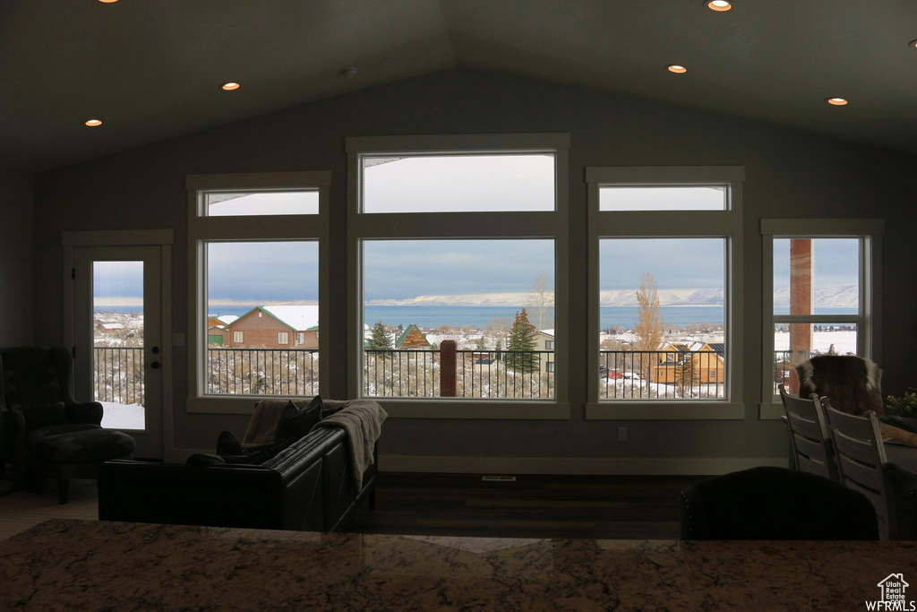 Interior space featuring lofted ceiling, a water view, and a healthy amount of sunlight