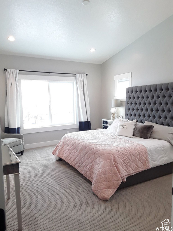 Bedroom with baseboards, multiple windows, vaulted ceiling, and carpet flooring