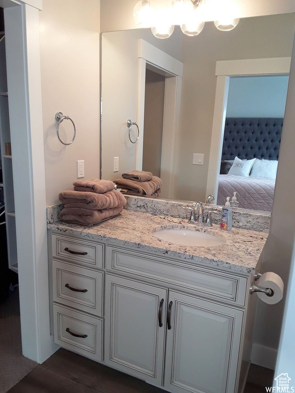 Ensuite bathroom featuring ensuite bath, wood finished floors, and vanity