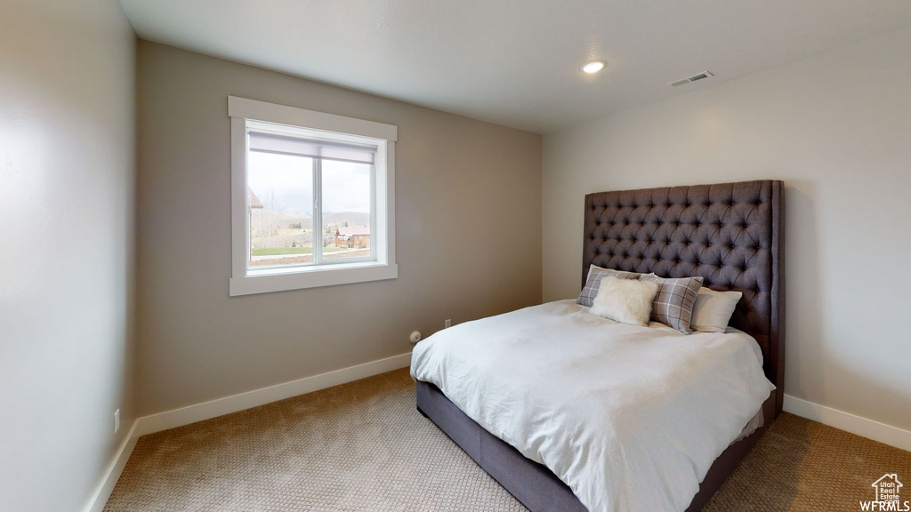 Carpeted bedroom with recessed lighting, visible vents, and baseboards