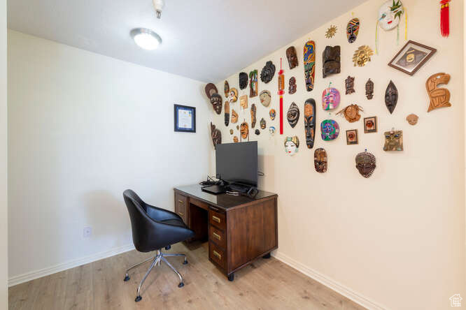 Home office with light wood-style flooring and baseboards