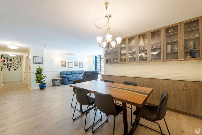 Dining room featuring a chandelier, light wood-style flooring, and baseboards