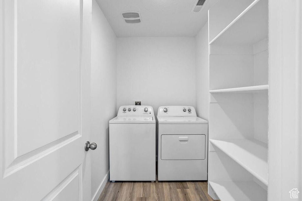 Laundry room featuring laundry area, washer and clothes dryer, dark wood finished floors, and visible vents