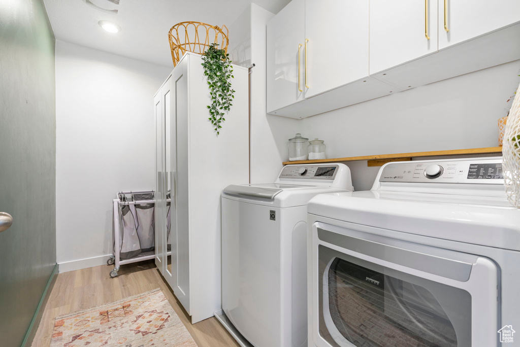 Laundry room featuring cabinet space, baseboards, light wood-style floors, separate washer and dryer, and recessed lighting