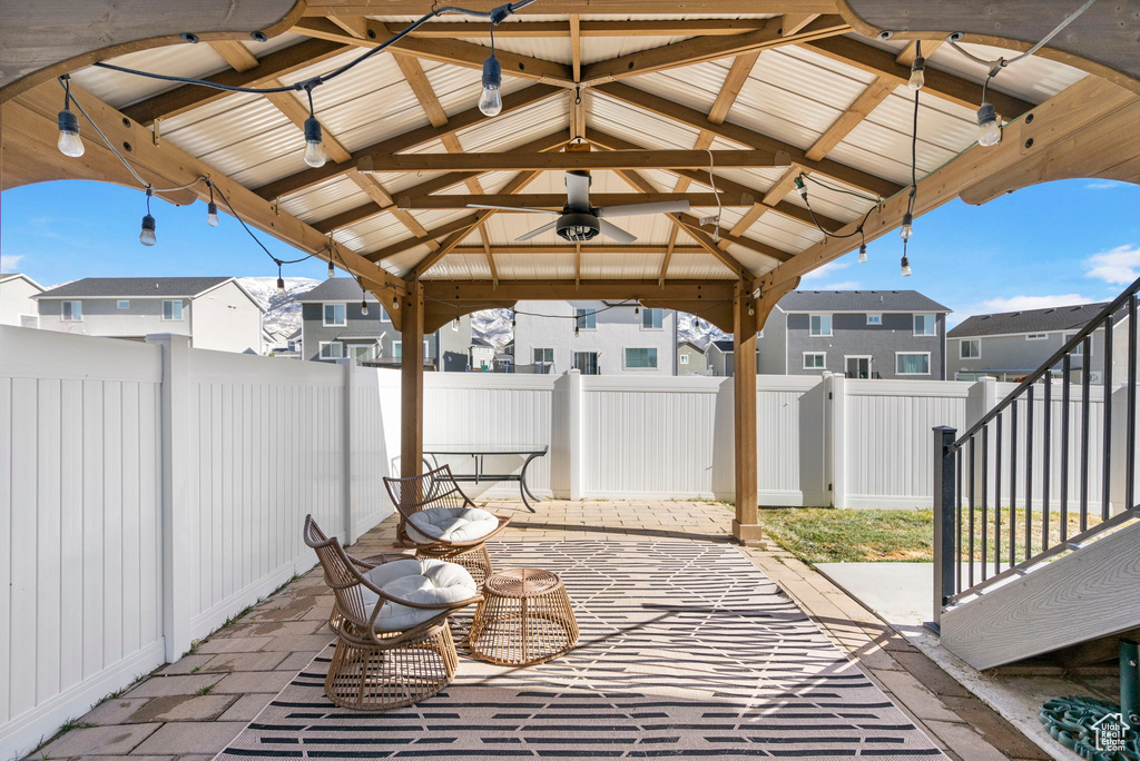 View of patio / terrace with a fenced backyard, a residential view, a ceiling fan, and a gazebo