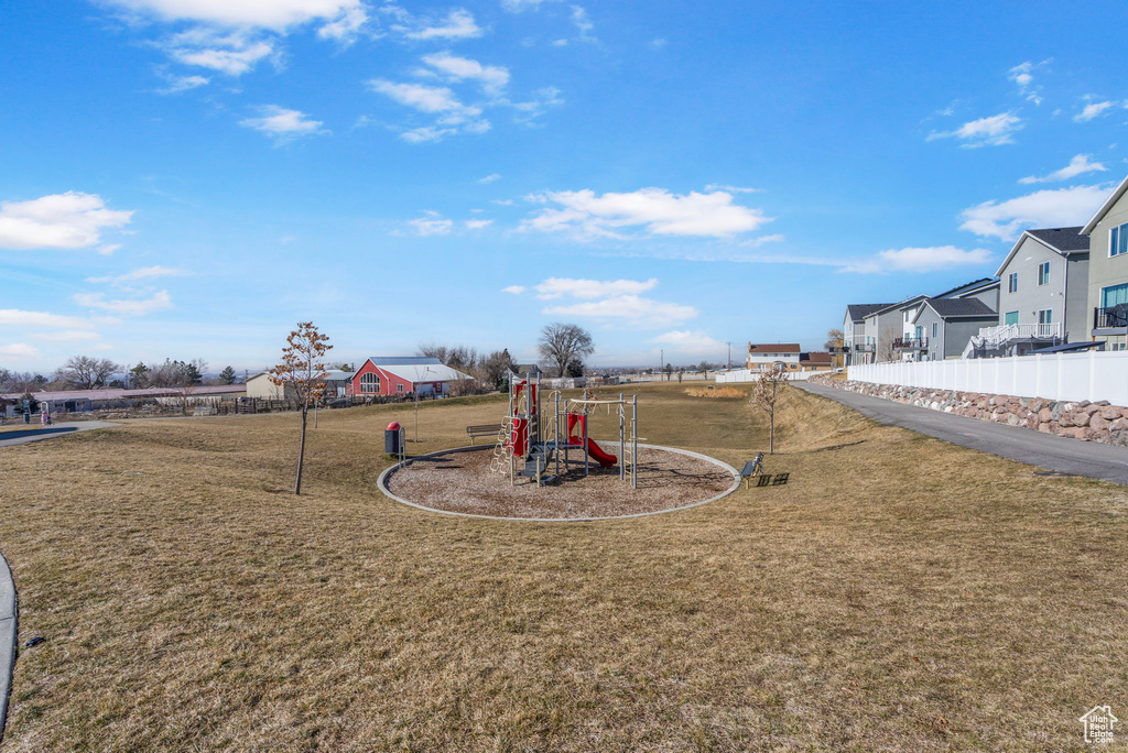 Community playground featuring a residential view, a yard, and fence