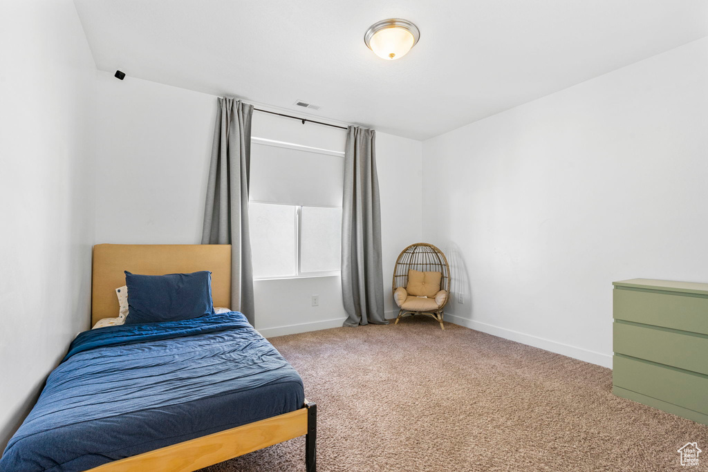 Carpeted bedroom with baseboards and visible vents