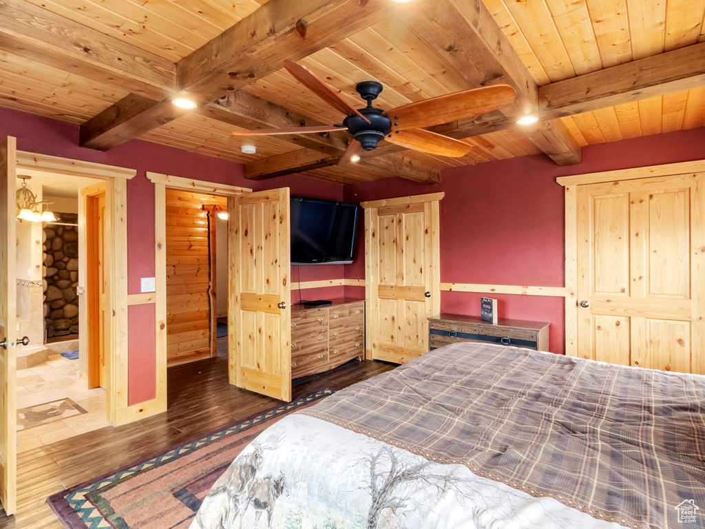 Bedroom with wooden ceiling with exposed beams and dark wood-style floors