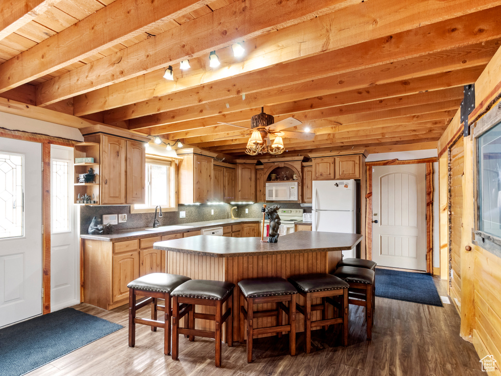 Kitchen with white appliances, beamed ceiling, wood finished floors, open shelves, and a kitchen island