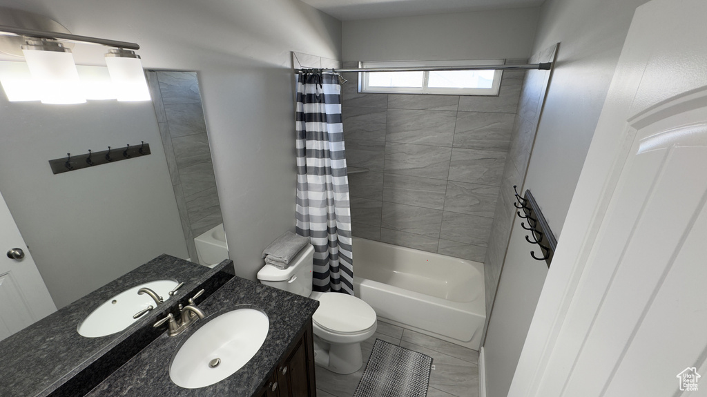 Full bath featuring shower / bathtub combination with curtain, toilet, and vanity