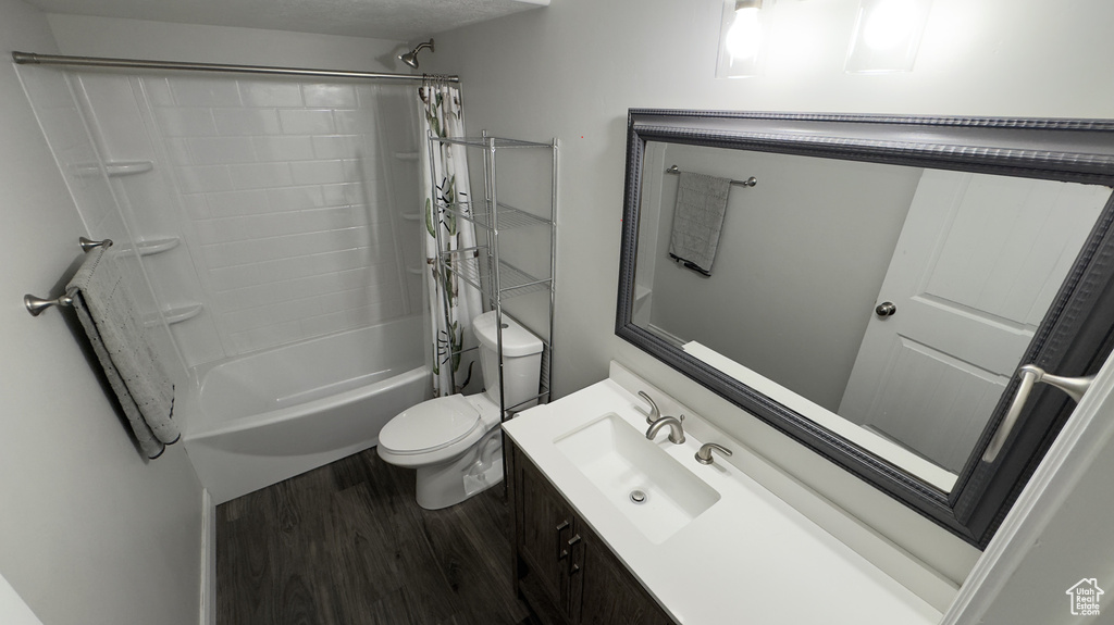 Full bathroom featuring vanity, shower / bath combination with curtain, wood finished floors, and toilet