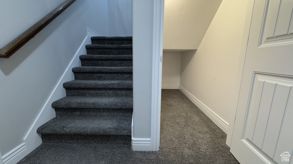 Stairs with carpet floors, lofted ceiling, and baseboards