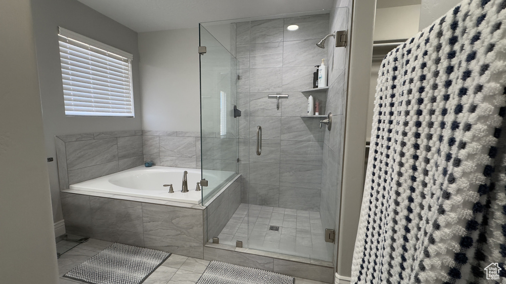 Bathroom with a shower stall and a bath